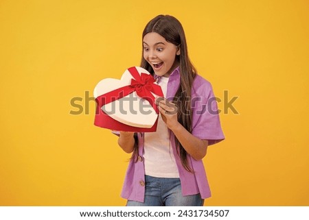 surprised teen girl holding heart box for Valentines Day