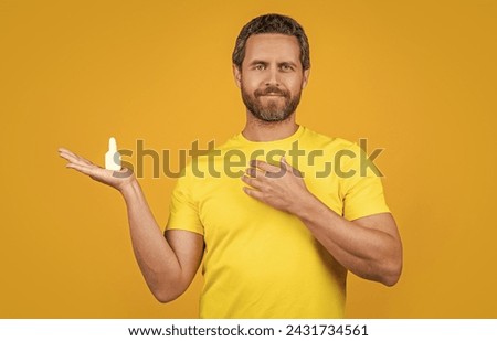 image of man with nasal medicine drops. man with nasal medicine isolated on yellow. Royalty-Free Stock Photo #2431734561