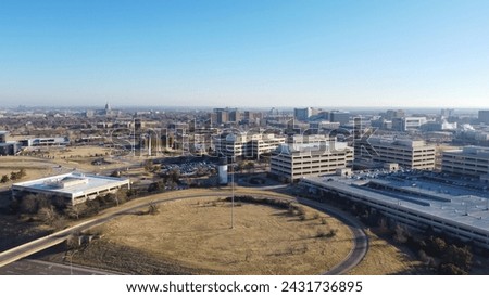 Interstate highway loop along Centennial Expressway or I-235 Central Northeast of Oklahoma City downtown, office buildings, rooftop parking garage, skyline high rises skyscraper background. Aerial