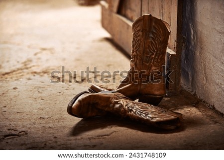 Cowboy boots, ranch and style at farm for walking, safety and retro fashion on floor, ground and barn. Shoes, leather product and vintage heel with pattern for steps, western aesthetic or culture Royalty-Free Stock Photo #2431748109