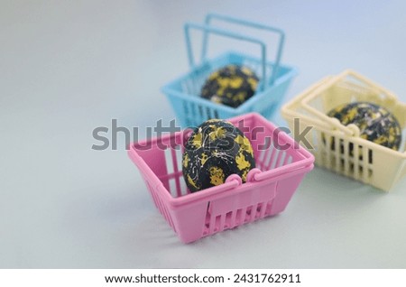 Easter eggs lie in a shopping basket. eggs are dark in color with yellow spots and white dots and stripes.