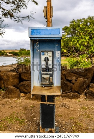 Pay phone near the sea. Telephone old school outdoor public phone . Operator I need a dime to place a call or perhaps a quarter. Retro vintage outdoor telephone in Hawaii out of order