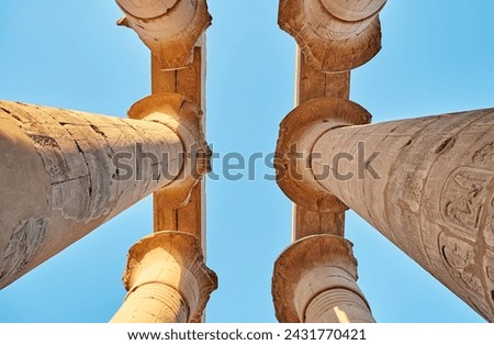 Different hieroglyphs on the walls and columns in the Karnak temple. Columns and blue sky in the great hypostyle hall at the Luxor temple, Egypt Royalty-Free Stock Photo #2431770421