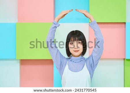 Colorful background with young woman doing ok hand sign