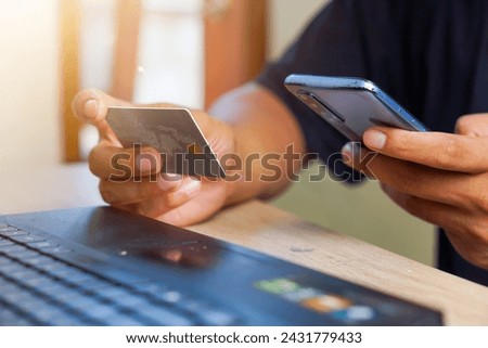 close-up portrait of a hand holding a credit card and a smart phone. Contactless payment with online in Mobile App