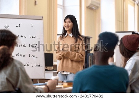 Portrait of smiling young Asian woman teaching Chinese language to diverse group of students copy space Royalty-Free Stock Photo #2431790481