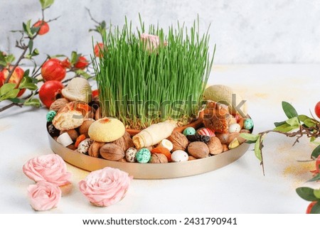 Traditional Azerbaijan holiday Novruz background with green semeni and xoncha with azerbaijan sweets.