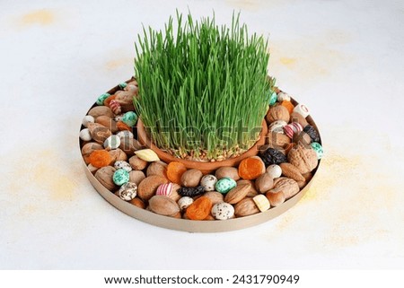 Traditional Azerbaijan holiday Novruz background with green semeni and xoncha with azerbaijan sweets.
