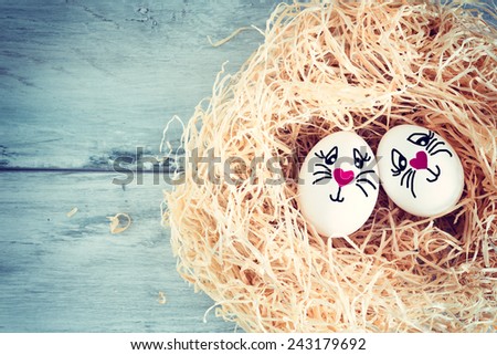 White egg with funny face in straw