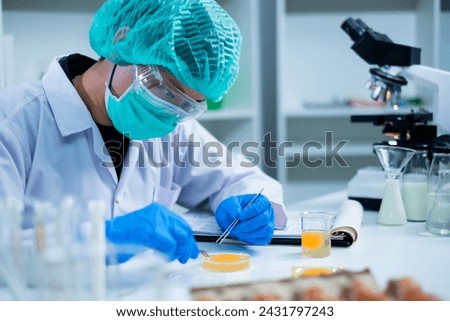 Professional Scientist or nutritionist do an experiment or research with egg yolk in laboratory, concept of microbiology, biochemistry, biotechnology, livestock factory or farm quality control protein