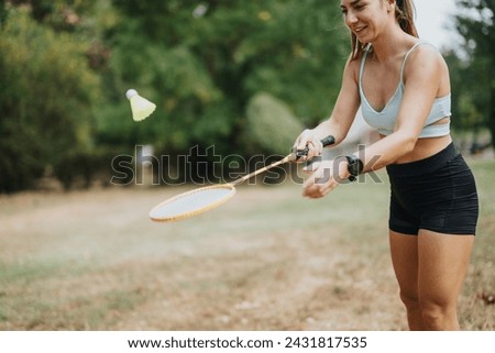 Fit and sporty girls playing badminton outdoors in a city park. They are having fun in the natural environment on a sunny day.