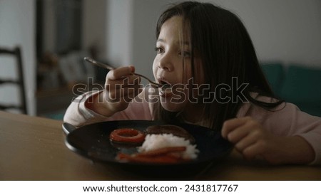 Little girl eating dinner at home. Child enjoying evening homemade plate. 8 year old kid dining Royalty-Free Stock Photo #2431817767