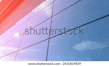 Wall of modern building with reflection of clouds