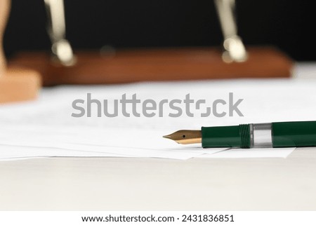 Signing notary document with fountain pen at light table, closeup. Space for text