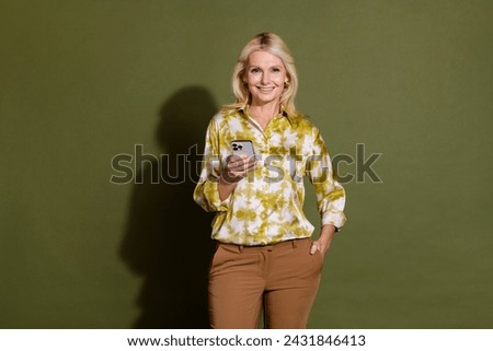 Photo of cheerful lovely female office manager holding modern device chatting online isolated on khaki color background
