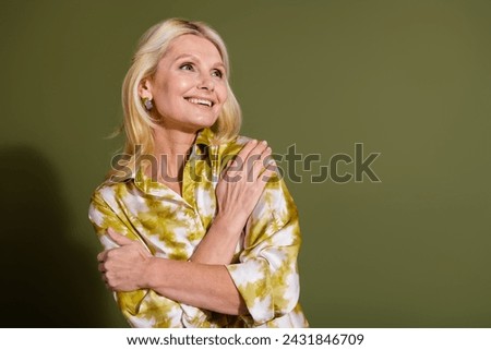 Photo of blonde hair senior age woman in yellow shirt hug cuddle herself cold temperature at office isolated on khaki color background