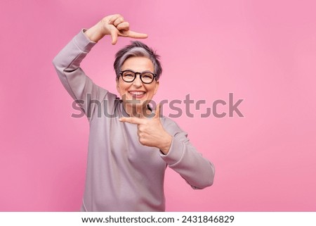 Photo of cheerful funny cute senior woman photographer video maker wear stylish clothes empty space isolated on pink color background