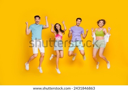 Full length photo of excited youngsters jumping raise fists up enjoy weekends discounts isolated shine color background