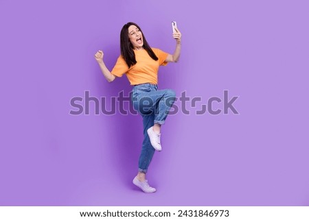 Full body size photo of overjoyed funny woman celebrate winning jackpot betting using smartphone isolated on violet color background
