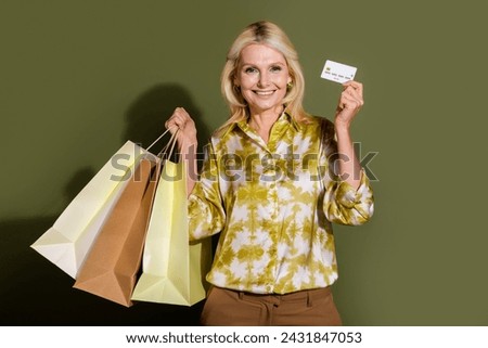 Photo of blonde hair senior woman business benefits spend salary on shopping hold gift packages isolated over khaki color background