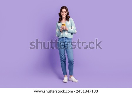 Full length photo of cool funky lady dressed flower print cardigan texting modern device isolated violet color background
