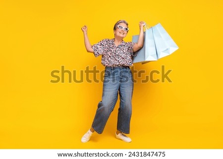 Full body photo of attractive pensioner woman lottery shopping bags wear trendy leopard print clothes isolated on yellow color background