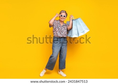 Full size photo of pretty retired female shopping bags summer sales wear trendy leopard print outfit isolated on yellow color background