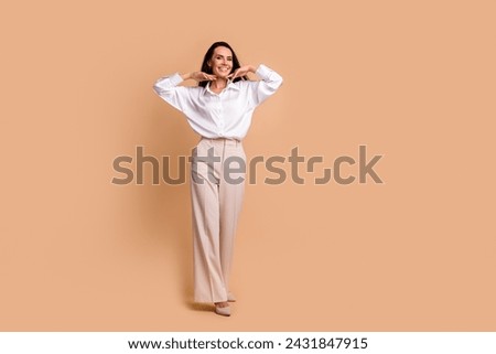 Full size portrait of stunning cheerful girl walk hands touch face empty space advert isolated on beige color background