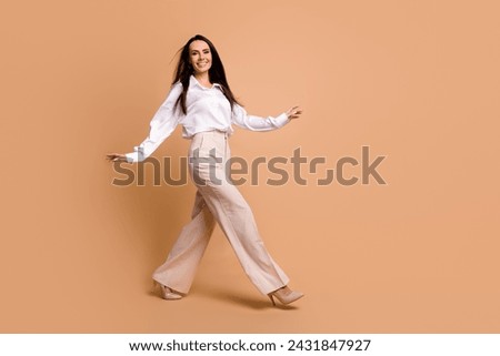 Full length photo of confident pretty woman wear white shirt walking high heels footwear empty space isolated beige color background