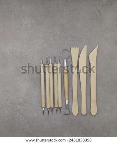 Combined wooden and metal sculpt tools on gray background