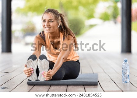 Female Athlete Outdoor training Stretching of all muscle groups Fitness exercises. Healthy sports lifestyle. Athletic young woman in sports dress doing fitness exercise. Fitness woman on stadium.