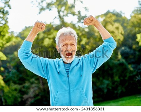 Smiling active senior man jogging exercising and having fun and celebrating success rasing hands taking a break in the park, concept of competition, winning, victory and strength Royalty-Free Stock Photo #2431856331