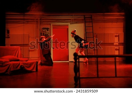 Actors and actresses play a modern performance of the show on the stage of the theater