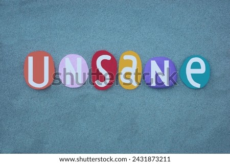 Unsane, a person with mental maps of reality are slightly out of correspondence, text with multi colored stone letters over green sand 
