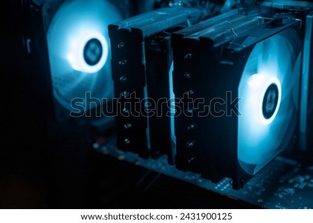 Detail of the interior of the PC gamer case. Motherboard, CPU tower cooling, memory, graphic card and RGB fans. professional gaming computer. Gaming PC with RGB LED lights hardware. Royalty-Free Stock Photo #2431900125