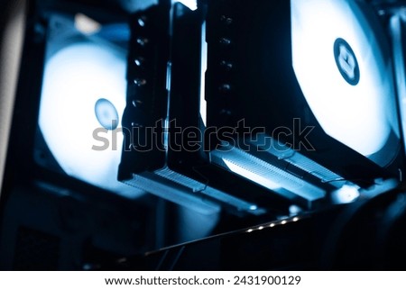 Detail of the interior of the PC gamer case. Motherboard, CPU tower cooling, memory, graphic card and RGB fans. professional gaming computer. Gaming PC with RGB LED lights hardware. Royalty-Free Stock Photo #2431900129