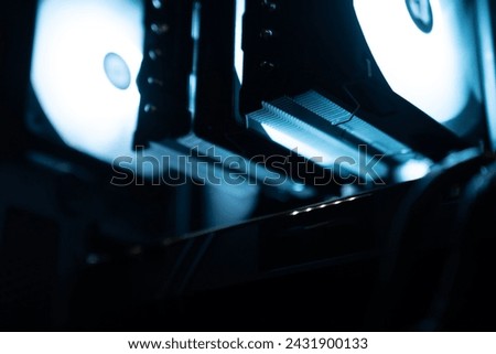 Detail of the interior of the PC gamer case. Motherboard, CPU tower cooling, memory, graphic card and RGB fans. professional gaming computer. Gaming PC with RGB LED lights hardware. Royalty-Free Stock Photo #2431900133