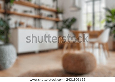 Blurred view of modern living room with sofa and soft bench. room interior with  couch, armchair and coffee table or shelving units. stylish living room. comfortable workplace near big window. Royalty-Free Stock Photo #2431903655