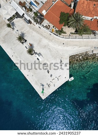 a picturesque corner of the small town called Hvar which is located on island Hvar. palms, red roofs and greenish-blue sea are in a perfect unison.   Royalty-Free Stock Photo #2431905237