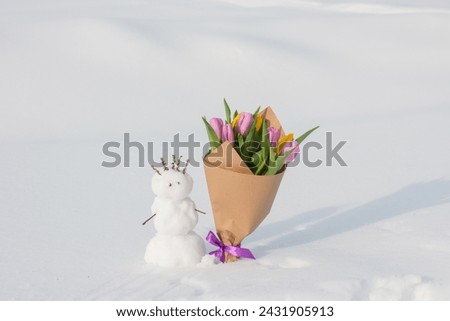 A spring bouquet of tulips next to a snowman. International Women's Day on March 8, greeting card
