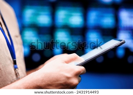 Close up shot of computer scientist using tablet to check server hub security features protecting against unauthorized access, data breaches, ddos attacks and other cybersecurity threats Royalty-Free Stock Photo #2431914493