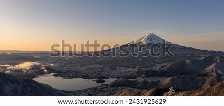 Panoramic view of snow-capped Mt. Fuji and Kawaguchiko-lake at sunrise. Royalty-Free Stock Photo #2431925629