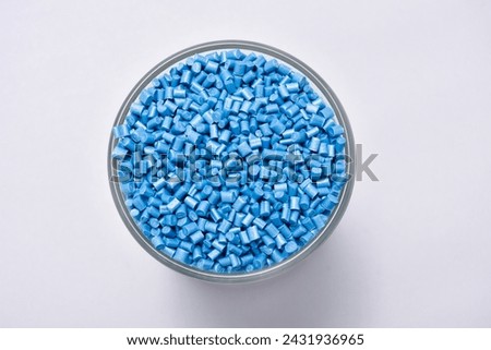Pearl blue masterbatch granules in a glass cup isolated on a white background, a special dye for polymer materials, used to color products in the plastics industry Royalty-Free Stock Photo #2431936965