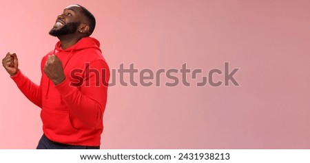 Lifestyle. Extremely happy excited young african american man win lottery bet standing pleased jumping joyfully triumphing clench fists celebrating success look up smiling say yes finally accomplish Royalty-Free Stock Photo #2431938213