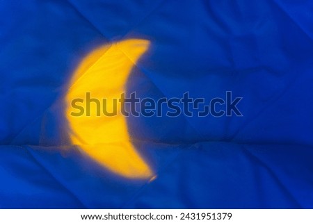 Yellow Light from Night Crescent, Moon on Bed Blanket. Background concept for cosmetics for night skin care, melatonin and cannabidiol products, for beauty, relaxation and improved sleep quality Royalty-Free Stock Photo #2431951379
