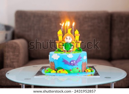 A colorful birthday cake with several lit candles