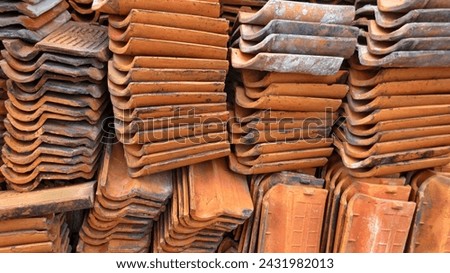 A pile of used clay roof tiles.