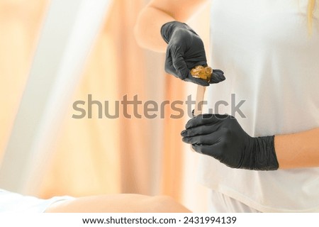 Portrait of a female caucasian beautician holding a jar of sugar paste for sugaring.