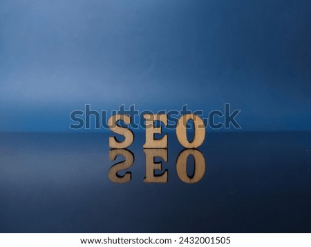 Wooden word with word SEO on a black acrylic board with reflection