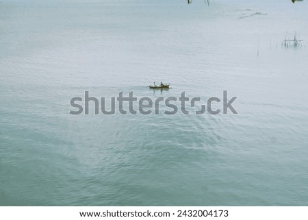 A picture of a fishing boat in the middle of a lake 